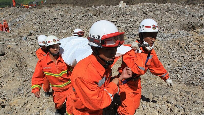 En una fotografía de archivo, rescatistas transportan el cuerpo de una víctima tras un deslizamiento de tierra ocurrido en una mina de mineral de hierro el 31 de julio de 2012 en Xinyuan, China. (Getty Images)