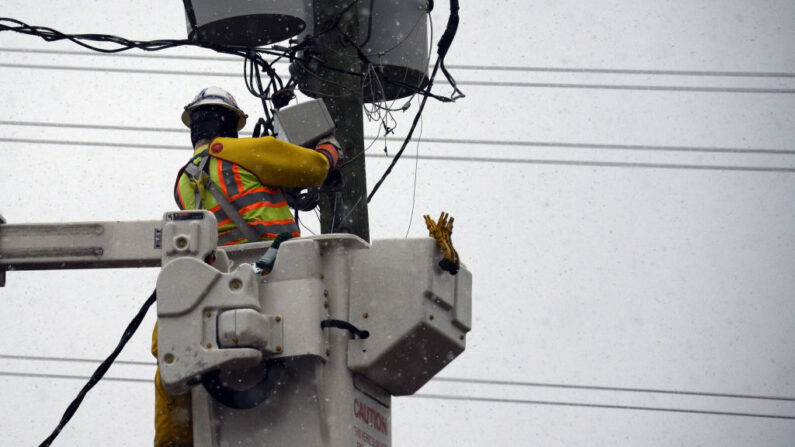 Un trabajador eléctrico hace reparaciones en un poste de servicios públicos durante una tormenta de nieve el 17 de enero de 2018 en Raleigh, Carolina del Norte. (Lance King/Getty Images)