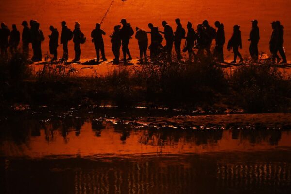 Inmigrantes ilegales que viajan en una caravana de más de 1000 personas cruzan el río Bravo hacia Estados Unidos, en Ciudad Juárez, estado de Chihuahua, México, el 11 de diciembre de 2022. (Herika Martinez/AFP vía Getty Images)
