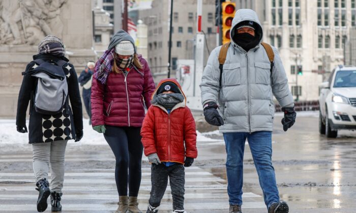 Algunas personas cruzan la calle en la Avenida Michigan de Chicago desafíando el clima helado antes de las vacaciones de Navidad el 23 de diciembre de 2022. (Kamil Krzaczynski/AFP vía Getty Images)