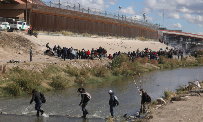 Inmigrantes caminando a través del Río Grande para entregarse a agentes de la Patrulla Fronteriza de Estados Unidos, en El Paso, Texas, desde Ciudad Juárez, México, el 13 de diciembre de 2022. (Herika Martinez/AFP/Getty Images)