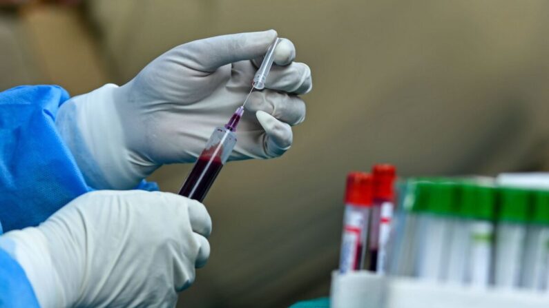 Un trabajador de la salud sostiene una muestra de sangre donada por un paciente recuperado de coronavirus COVID-19 para obtener plasma en un campamento de donación en Srinagar, India, el 22 de julio de 2020. (Tauseef Mustafa/AFP vía Getty Images)