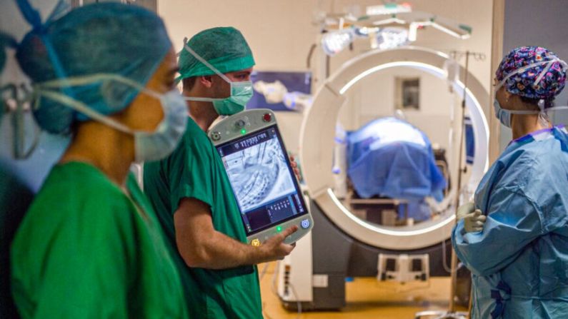 Un equipo de cirujanos utiliza un sistema de imágenes médicas en vivo Loop-X para asegurar el trabajo en la columna vertebral de una paciente afectada por un cáncer de mama metastásico en el hospital afiliado a la Universidad (CHU) en Angers, Francia, el 10 de junio del 2021. (AFP vía Getty Images/Loic Venance)