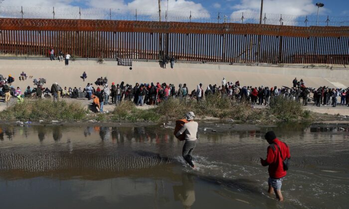 Inmigrantes ilegales cruzan el Río Grande para entregarse a los agentes de la Patrulla Fronteriza de EE. UU. en El Paso, Texas, vistos desde Ciudad Juárez, estado de Chihuahua, México, el 13 de diciembre de 2022. (Herika Martine/AFP vía Getty Images)