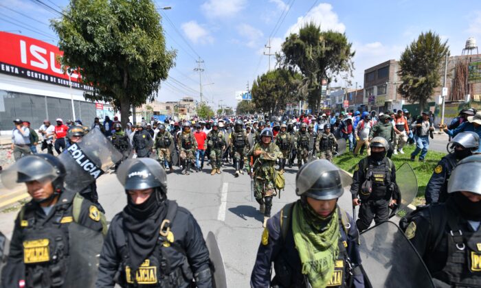 Miembros de la policía escoltan a partidarios del expresidente Pedro Castillo mientras marchan hacia el centro de la ciudad de Arequipa, Perú, exigiendo el cierre del Congreso y la liberación de Castillo, el 14 de diciembre de 2022. (Diego Ramos/AFP a través de Getty Images)