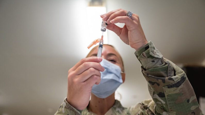 Una técnica llena una jeringa con una vacuna contra COVID-19 Janssen en Fort Knox, Kentucky, el 9 de septiembre de 2021. (Jon Cherry/Getty Images)