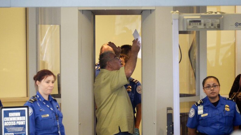 Un viajero entra en el control de seguridad ante la mirada de agentes de la Administración de Seguridad en el Transporte en el Aeropuerto Internacional de Los Ángeles en noviembre de 2013. (Kevork Djansezian/Getty Images)
