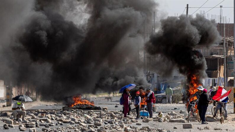 Personas caminan entre barricadas durante las manifestaciones, el 11 de enero de 2023, en la ciudad de Tacna (Perú). EFE/Rafael Arancibia