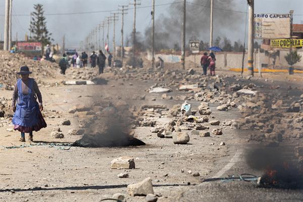 Una mujer camina entre barricadas durante las manifestaciones hoy, en la ciudad de Tacna, (Perú). EFE/ Rafael Arancibia
