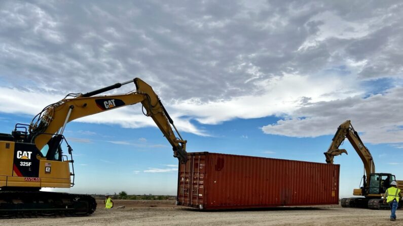Contratistas comienzan a apilar contenedores de envío en los espacios de la cerca fronteriza, en cercanías de Yuma, Arizona, el 12 de agosto de 2022. (Cortesía de la oficina del gobernador de Arizona)
