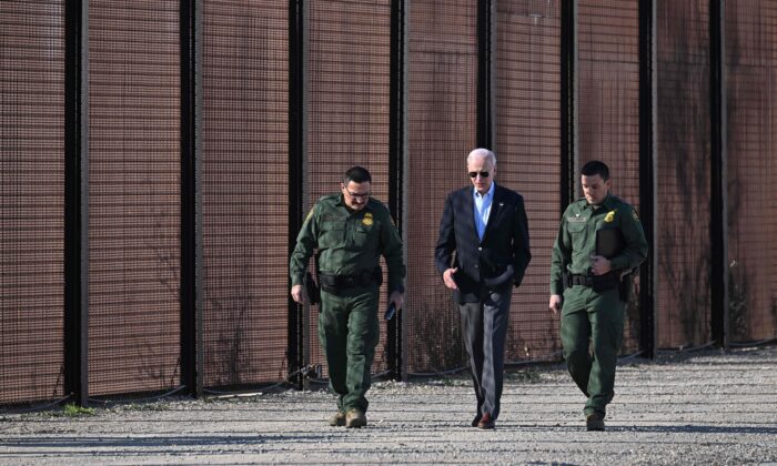 El presidente de Estados Unidos, Joe Biden, habla con un miembro de la Patrulla Fronteriza mientras caminan al costado de la valla fronteriza entre Estados Unidos y México, en El Paso, Texas, el 8 de enero de 2023. (Jim Watson/AFP vía Getty Images)