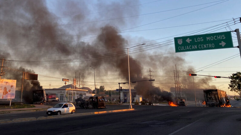 Vehículos en llamas se ven cruzados en la calle durante una operación para detener al hijo de Joaquín "El Chapo" Guzmán, Ovidio Guzmán, en Culiacán, estado de Sinaloa, México, el 5 de enero de 2023. (Marcos Vizcarra/AFP vía Getty Images)