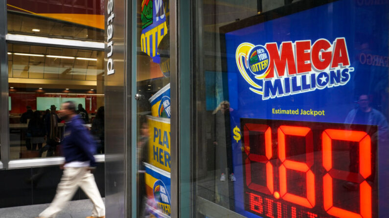 Un hombre pasa frente a un puesto de periódicos con anuncios de la lotería Mega Millions, el 23 de octubre de 2018 en la ciudad de Nueva York. (Drew Angerer/Getty Images)