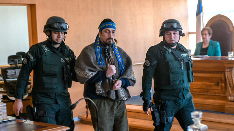 Fotografía difundida por Aton Chile del líder mapuche argentino Facundo Jones Huala siendo escoltado a su llegada a un tribunal en Valdivia, Chile, el 12 de septiembre de 2018, después de que el presidente argentino Mauricio Macri firmara su extradición para ser juzgado por un incendio provocado en 2013. (MIGUEL ANGEL BUSTOS/ATON CHILE/AFP via Getty Images)