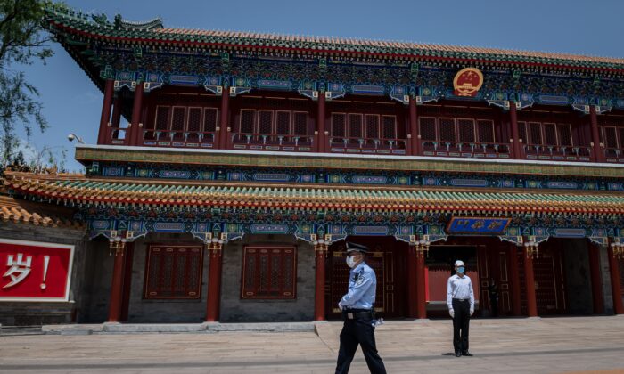 Un guardia de seguridad (de) y un agente de policía (iz) aseguran la zona a la entrada de Zhongnanhai, el complejo de liderazgo del Partido Comunista Chino, en Pekín el 18 de mayo de 2020. (Nicolas Asfouri/AFP vía Getty Images)
