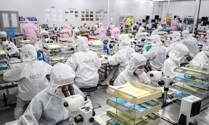 Trabajadores producen chips LED en una fábrica en Huaian, en la provincia oriental china de Jiangsu, el 16 de junio de 2020. (STR/AFP vía Getty Images)
