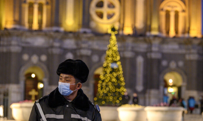 Un guardia de seguridad con mascarilla hace guardia en la Iglesia de San José durante una misa en la víspera de Navidad en Beijing, el 24 de diciembre de 2020. (Noel Celis/AFP vía Getty Images)