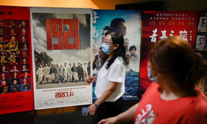 La gente pasa frente a un cartel de "1921", una película de propaganda sobre la fundación del Partido Comunista Chino (PCCh) en el mismo año, antes del centenario de la fundación del PCCh, en un cine en Beijing, el 28 de junio de 2021. (Wang Zhao/AFP vía Getty Images)