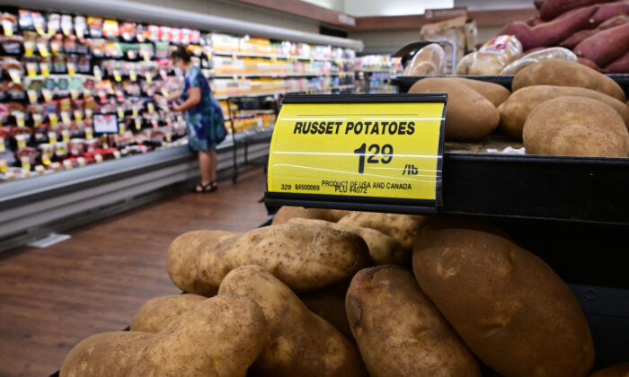 Un compradora detrás de un letrero que muestra el precio de 1 libra de papas rojas en un supermercado, en Montebello, California, el 23 de agosto de 2022. (Frederic J. Brown/AFP vía Getty Images)
