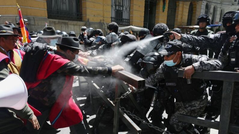Campesinos indígenas de la provincia de Omasuyos, en el altiplano boliviano, llamados "Ponchos Rojos", se enfrentan a la policía antidisturbios, el 5 de octubre de 2022. (AIZAR RALDES/AFP vía Getty Images)