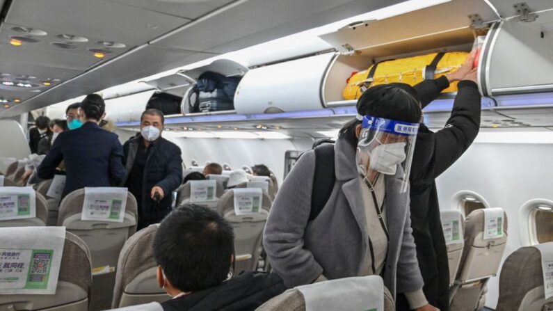 Un pasajero con mascarilla y protector facial en medio de la pandemia de covid-19 embarca en un vuelo nacional en el Aeropuerto Internacional de Shanghai Pudong en Shanghai (China) el 3 de enero de 2023. (Hector Retamal/AFP vía Getty Images)