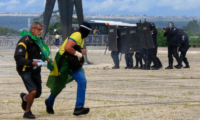 Las fuerzas de seguridad se enfrentan a los partidarios del expresidente brasileño Jair Bolsonaro mientras invaden el Palacio Presidencial de Planalto en Brasilia, el 8 de enero de 2023. (SERGIO LIMA/AFP a través de Getty Images)
