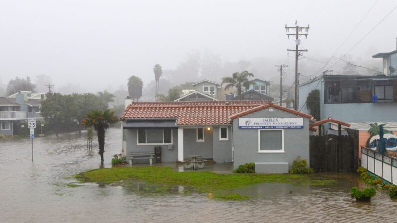 Un hombre observa un barrio inundado desde el segundo piso de un edificio en Aptos, California, el 9 de enero de 2023. (JOSH EDELSON/AFP vía Getty Images)
