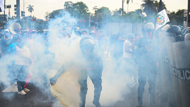 Un policía lanza humo mientras la gente protesta contra el gobierno de la presidenta peruana Dina Boluarte en Lima el 17 de enero de 2023. (Ernesto Benavides/AFP vía Getty Images)