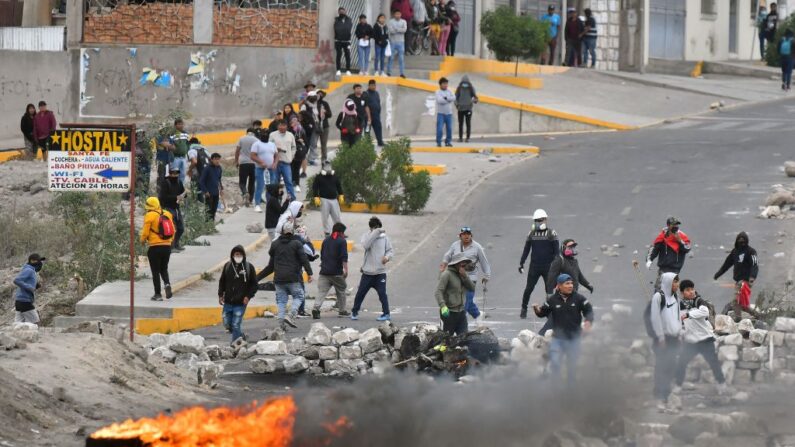 Manifestantes encienden una hoguera en el puente Añashuayco, cerca del aeropuerto Rodríguez Ballón, en Arequipa, Perú, durante una protesta contra el gobierno de la presidenta Dina Boluarte y para exigir su renuncia el 20 de enero de 2023. (Diego Ramos/AFP vía Getty Images)