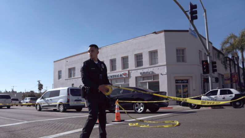 Un oficial de policía coloca una cinta para escenas de crimen cerca del sitio donde se presentó un tiroteo mortal, en Monterey Park, California, el 22 de enero de 2023. (Eric Thayer/Getty Images)