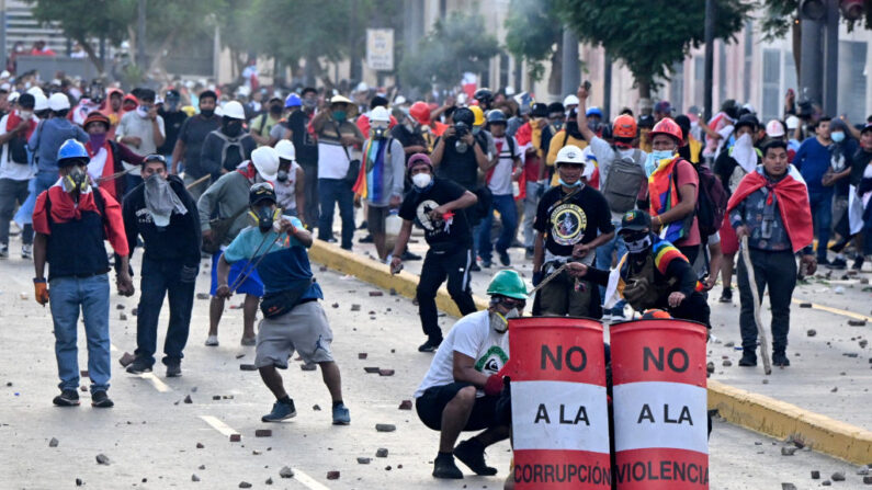 Manifestantes lanzan piedras a la policía antidisturbios durante los enfrentamientos dentro de una protesta contra el gobierno de Dina Boluarte pidiendo su renuncia y el cierre del Congreso, en Lima (Perú) el 24 de enero de 2023. (Ernesto Benavides/AFP vía Getty Images)