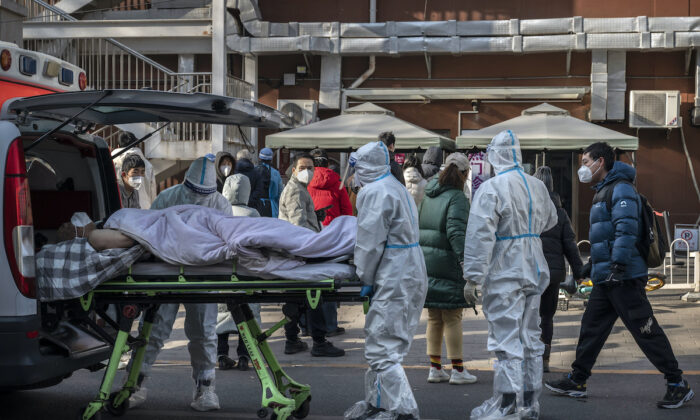 Trabajadores médicos llevan EPP mientras llegan con un paciente en una camilla a una clínica de fiebre el 9 de diciembre de 2022 en Beijing, China.(Kevin Frayer/Getty Images)
