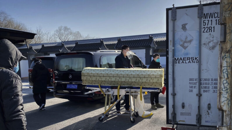 Un ataúd se carga desde un coche fúnebre a un contenedor de almacenamiento en el crematorio y funeraria Dongjiao, uno de los varios de Beijing que se ocupan de los casos de COVID-19, en China, el 18 de diciembre de 2022. (Getty Images)