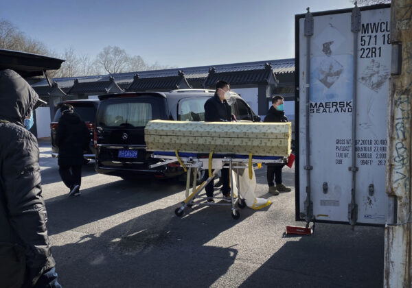 Un ataúd es cargado desde un coche fúnebre a un contenedor de almacenamiento en el crematorio y funeraria Dongjiao, una de varias funerarias de la ciudad usadas para los casos de COVID-19, en Beijing, el 18 de diciembre de 2022. (Getty Images)