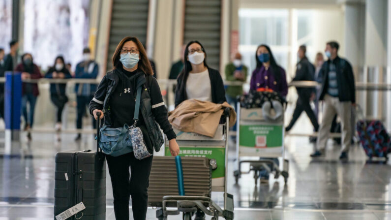 Viajeros caminan con su equipaje en la sala de llegadas del Aeropuerto Internacional de Hong Kong el 30 de diciembre de 2022. (Anthony Kwan/Getty Images)
