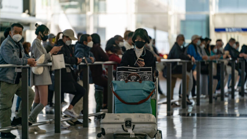 Viajeros caminan con su equipaje en la sala de llegadas del Aeropuerto Internacional de Hong Kong el 30 de diciembre de 2022 en Hong Kong, China. (Anthony Kwan/Getty Images)