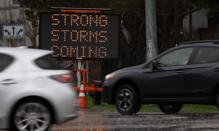 Coches circulan junto a una señal que advierte la llegada de tormentas para la zona de la bahía en Sausalito, California, el 7 de enero de 2023. (Justin Sullivan/Getty Images)