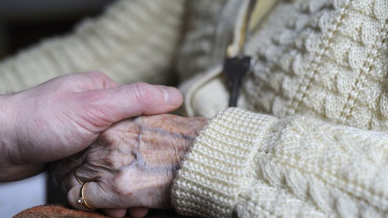 Una mujer, enferma de Alzheimer, sostiene la mano de un familiar el 18 de marzo de 2011 en una residencia de ancianos. (Sebastien Bozon/AFP vía Getty Images)