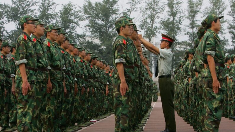 Un oficial militar ajusta la gorra de un estudiante durante un entrenamiento militar en la Universidad Tsinghua de Beijing el 7 de septiembre de 2006. (China Photos/Getty Images)
