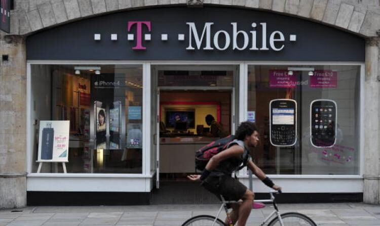 Un hombre pasa en bicicleta por delante de una tienda de T-Mobile en Fleet Street, Londres, Inglaterra. AT&T Inc. acordó el domingo la compra de la operadora de telefonía móvil T-Mobile, en una operación por valor de 39,000 millones de dólares en efectivo y acciones. (Carl Court/AFP/Getty Images)
