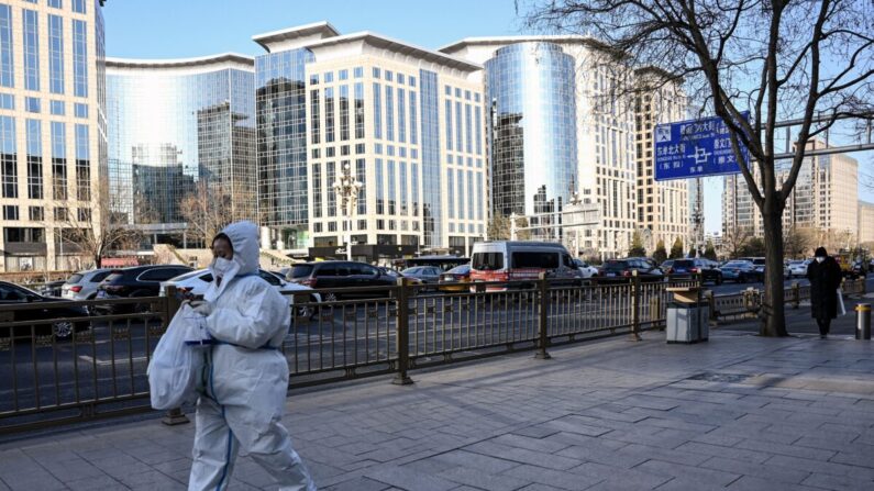 Una mujer con equipo de protección individual (EPI) en medio de la pandemia de COVID-19 camina por una calle de Beijing el 26 de diciembre de 2022. (Noel Celis/AFP vía Getty Images)
