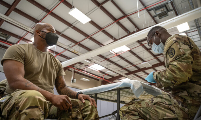 El sargento de primera clase del NCOIC, Demetrius Roberson, se prepara para administrar una vacuna contra el COVID-19 a un soldado, en Fort Knox, Ky., el 9 de septiembre de 2021. (Jon Cherry/Getty Images)
