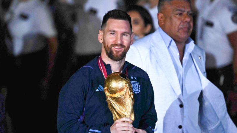 El capitán y delantero estrella de Argentina, Lionel Messi, sostiene el Trofeo de la Copa Mundial de la FIFA a su llegada al Aeropuerto Internacional de Ezeiza, Buenos Aires, el 20 de diciembre del 2022, después de ganar el torneo de la Copa Mundial 2022 en Qatar. (Getty Images/ Luis Robayo/AFP)