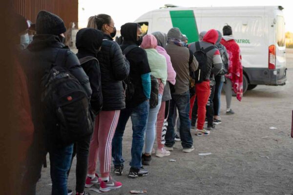 Extranjeros ilegales en busca de asilo hacen fila para ser procesados por agentes de la Patrulla Fronteriza y Aduanas de Estados Unidos en una brecha en la valla fronteriza México-Estados Unidos cerca de San Luis, Arizona, el 26 de diciembre de 2022. (Rebecca Noble/AFP vía Getty Images)