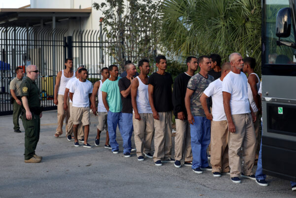Extranjeros ilegales procedentes de Cuba hacen cola para subir a un autobús para ser conducidos a una estación de Aduanas y Protección Fronteriza de EE. UU. mientras son procesados en Marathon, Florida, el 5 de enero de 2023. (Joe Raedle/Getty Images)