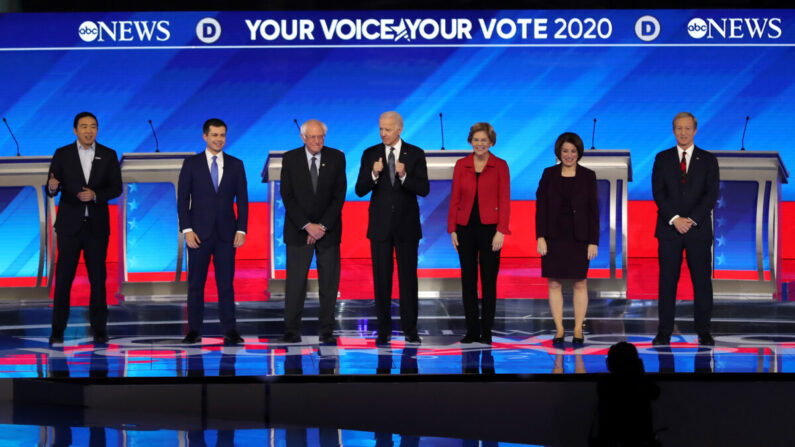 Los entonces candidatos presidenciales demócratas Andrew Yang, el ex alcalde de South Bend, Indiana, Pete Buttigieg, el senador Bernie Sanders (I-Vt.), Joe Biden, la senadora Elizabeth Warren (D-Mass.), la senadora Amy Klobuchar (D-Minn.), y Tom Steyer en el escenario al comienzo del debate de las primarias presidenciales demócratas en el Sullivan Arena del St. Anselm College en Manchester, New Hampshire, el 7 de febrero de 2020. (Joe Raedle/Getty Images)
