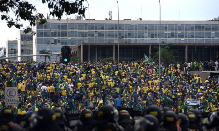 Manifestantes, muchos de los cuales apoyan al expresidente brasileño Jair Bolsonaro, rodean varios edificios gubernamentales mientras se enfrentan a las fuerzas de seguridad en Brasilia el 8 de enero de 2023. (Ton Molina/AFP vía Getty Images)
