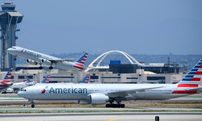 Un avión Airbus A321 de American Airlines despega (Detrás) mientras un Boeing 777-300 pasa por la pista (Delante) en el Aeropuerto Internacional de Los Ángeles (LAX) en Los Ángeles, California, el 6 de julio de 2021. (Patrick Fallon/AFP vía Getty Images)