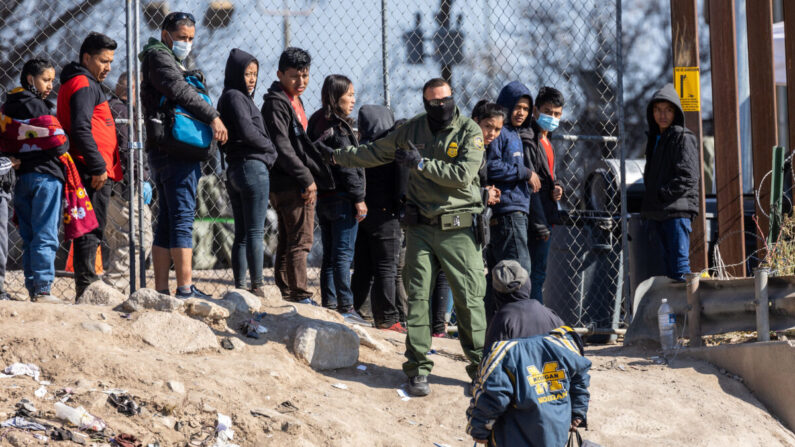 Un agente de la Patrulla Fronteriza da instrucciones a inmigrantes ilegales que cruzaron el Río Grande hacia El Paso, Texas, visto desde Ciudad Juárez, México, el 19 de diciembre de 2022. (John Moore/Getty Images)
