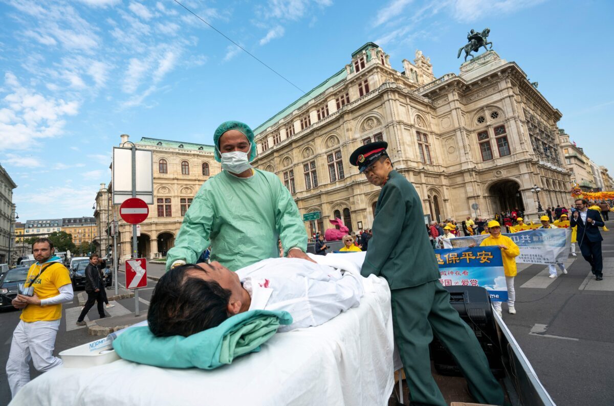 Practicantes de Falun Gong escenifican un simulacro de la sustracción forzada de órganos de practicantes encarcelados en China durante una protesta contra la importación de órganos humanos de China a Austria, en Viena, el 1 de octubre de 2018. (Joe Klamar/AFP vía Getty Images)